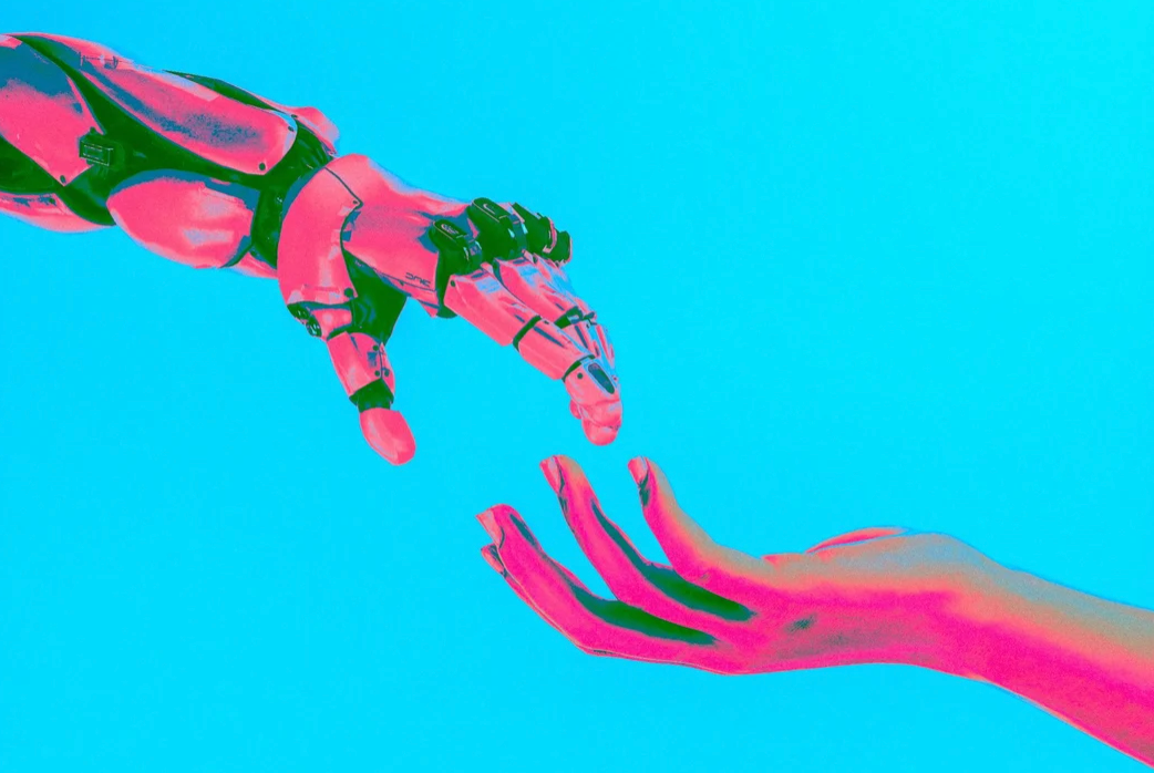A pink-tinted robotic hand and a human hand reach toward each other against a bright blue background, their fingers nearly touching.